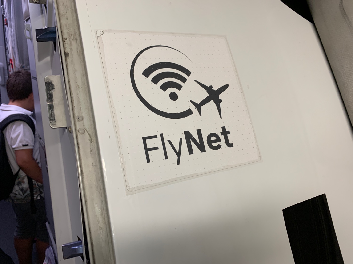 a white sign with a plane and wifi symbol on it