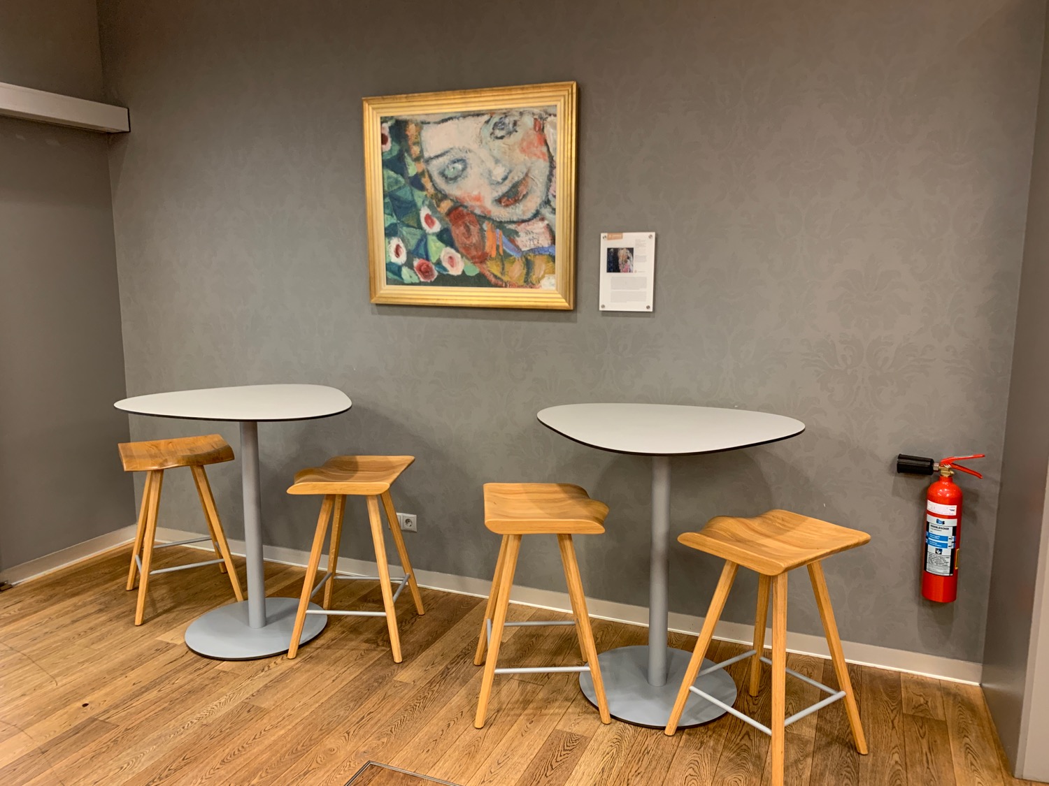 a table and stools in a room with a painting on the wall