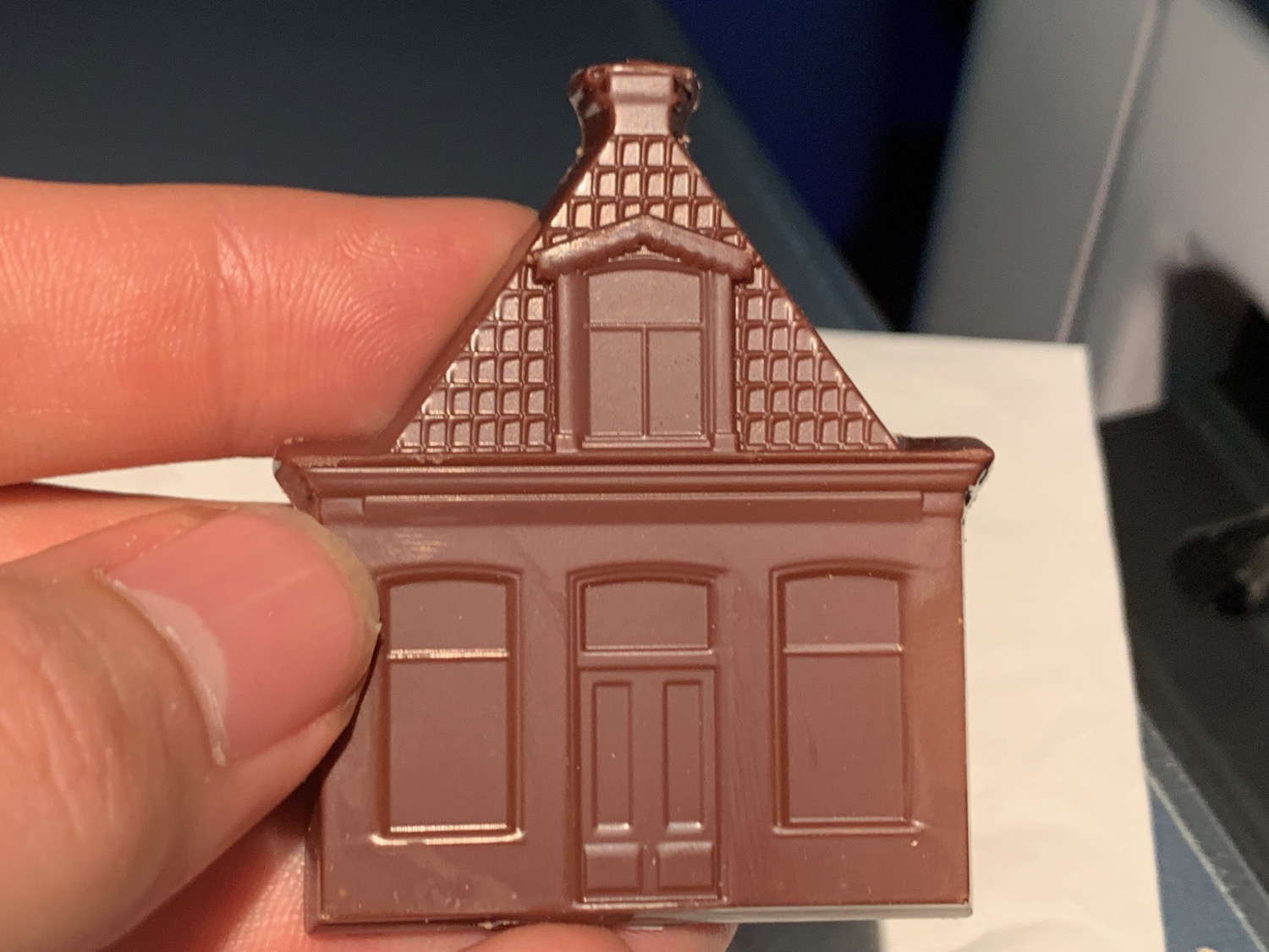a hand holding a chocolate house