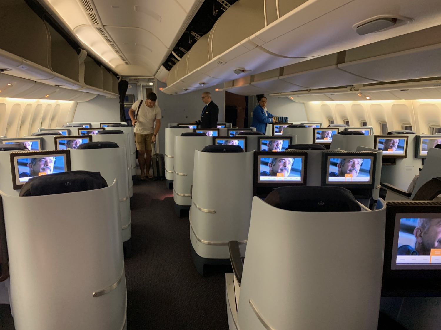 a group of people standing in a row of seats with monitors on the side