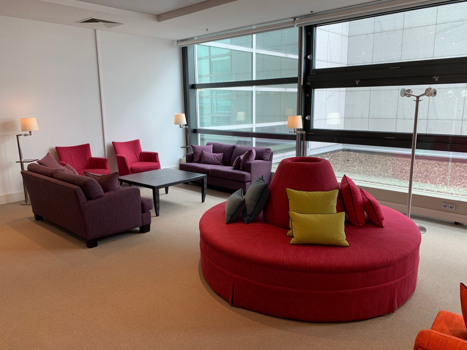 a room with a red couch and purple chairs