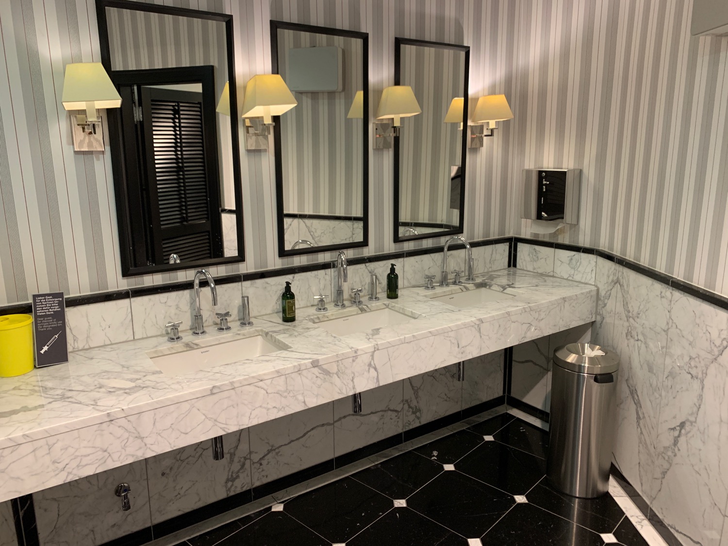 a bathroom with marble counter tops and mirrors