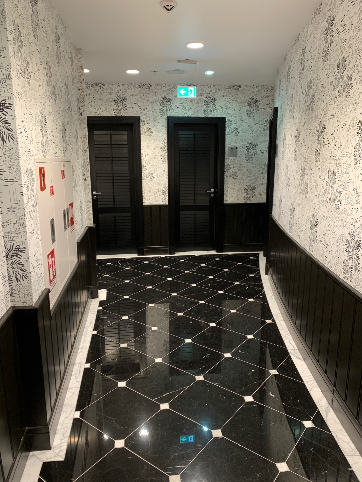a hallway with black and white tile floor