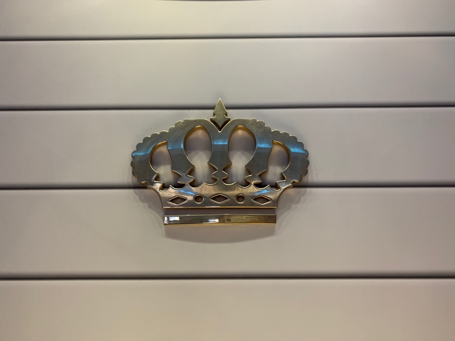 a metal crown on a white wall