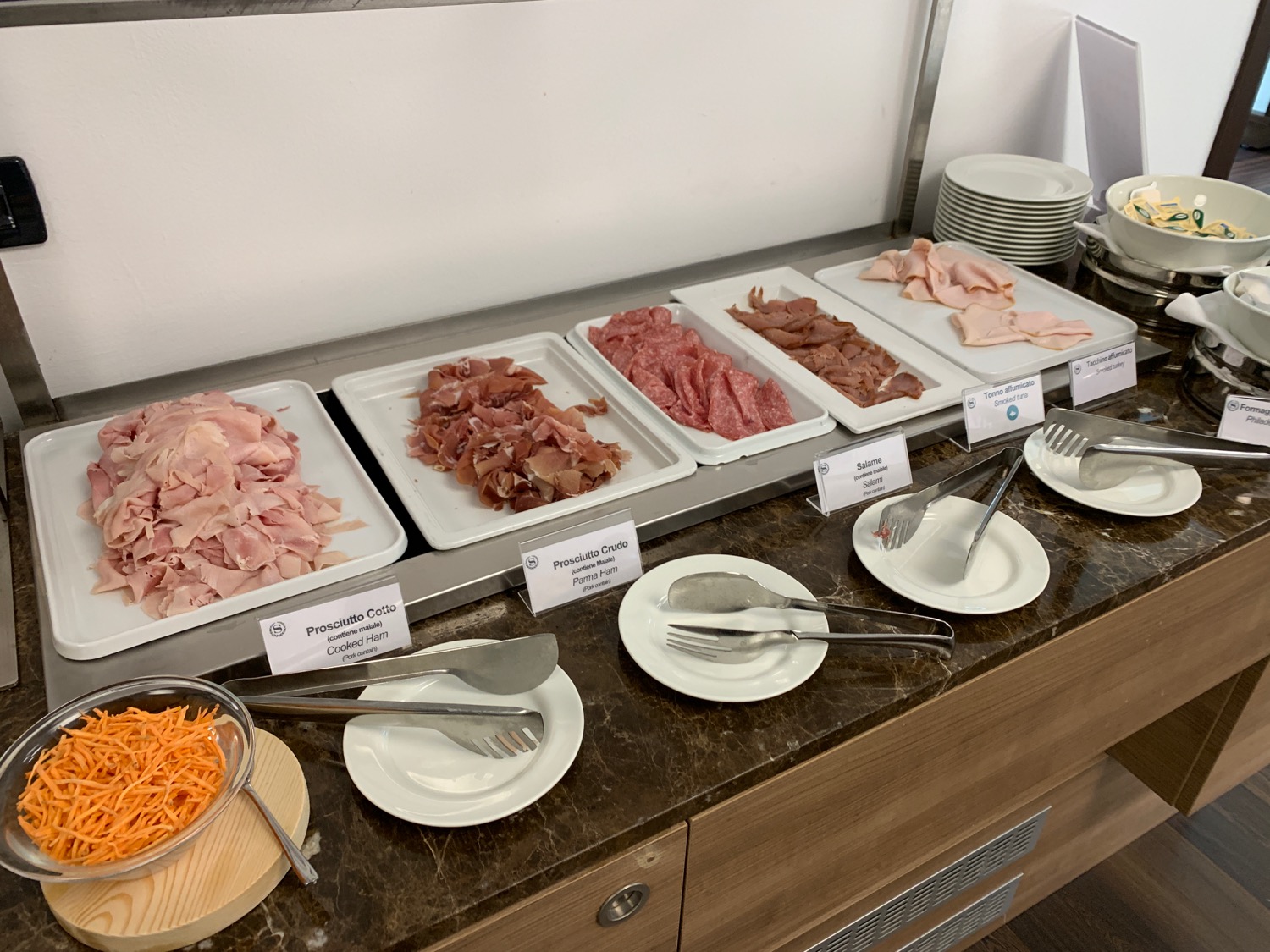a buffet with different types of meats and forks