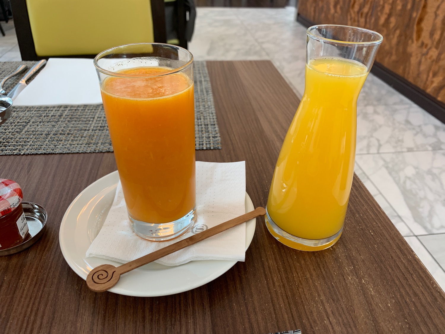 a glass of orange juice and a bottle of orange juice on a plate