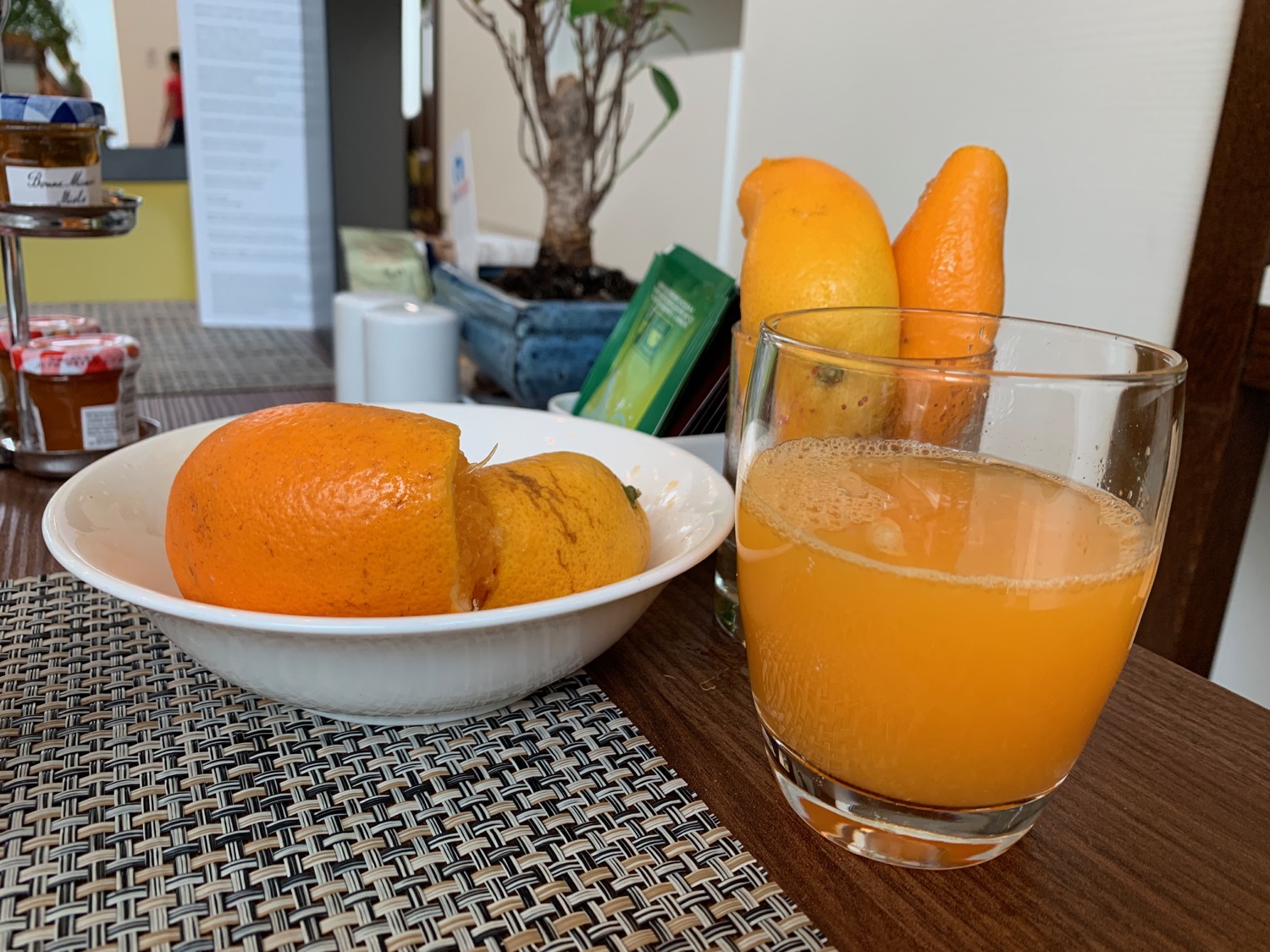 a bowl of oranges and a glass of orange juice