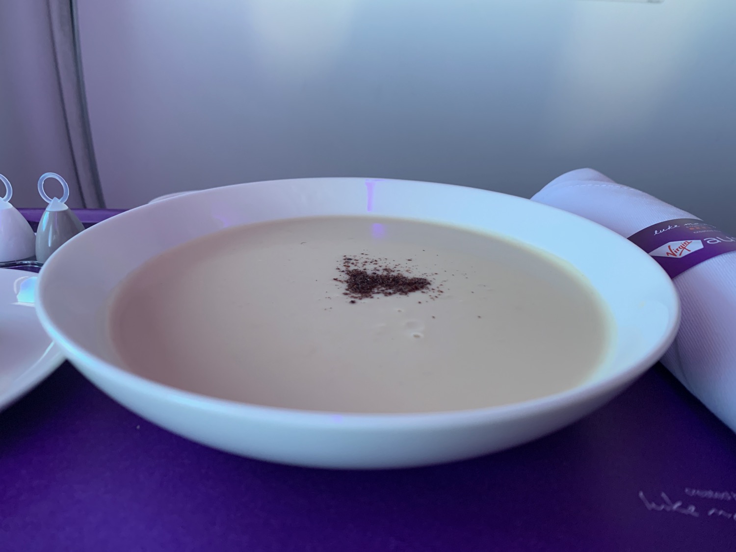 a bowl of soup on a purple surface