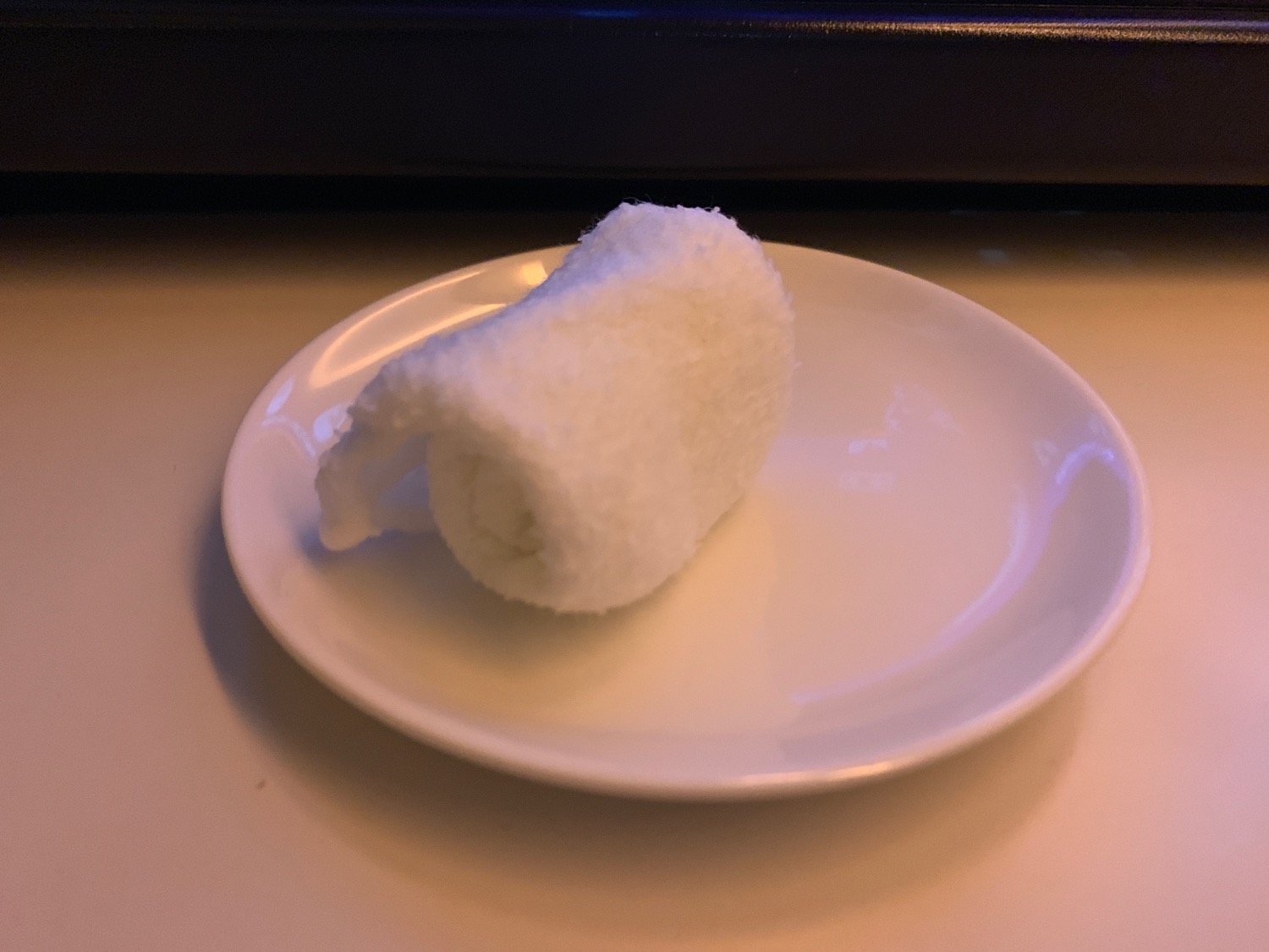 a white towel roll on a white plate