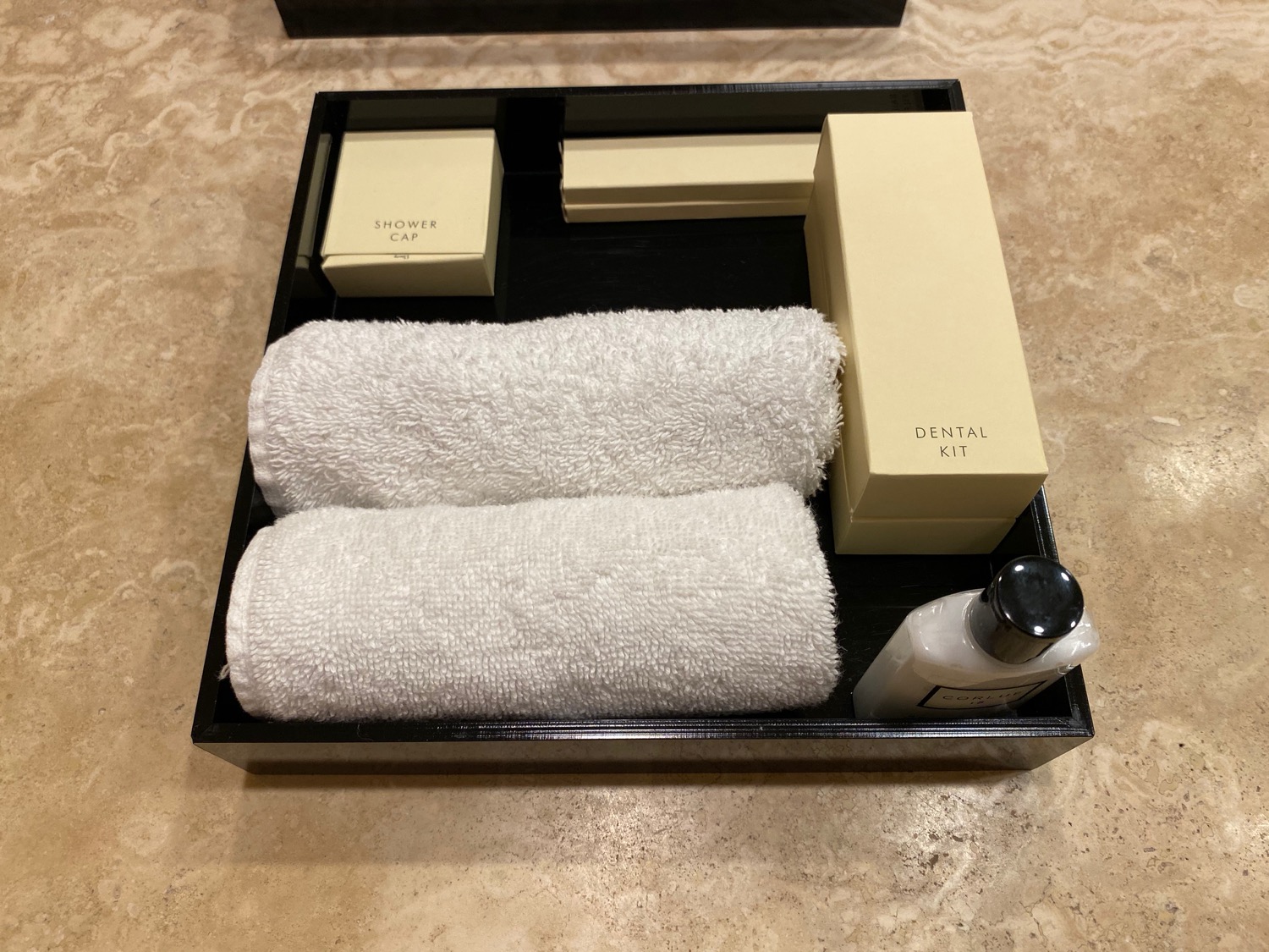 a black box with a white towel and a bottle of shampoo