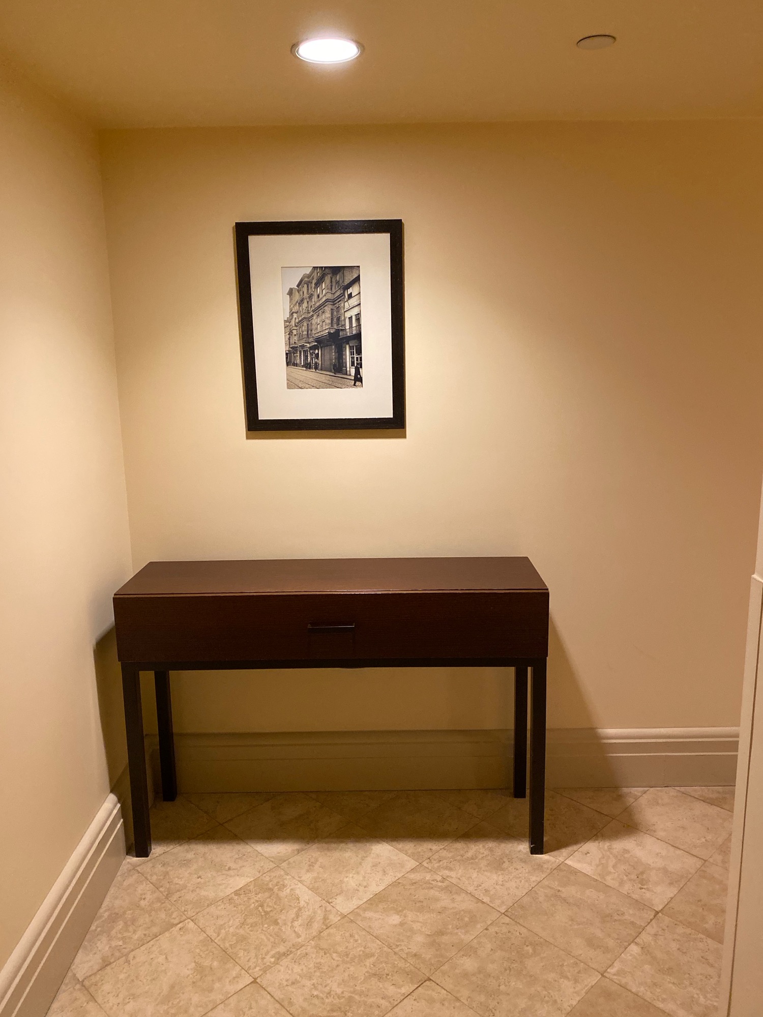 a table and a framed picture on the wall