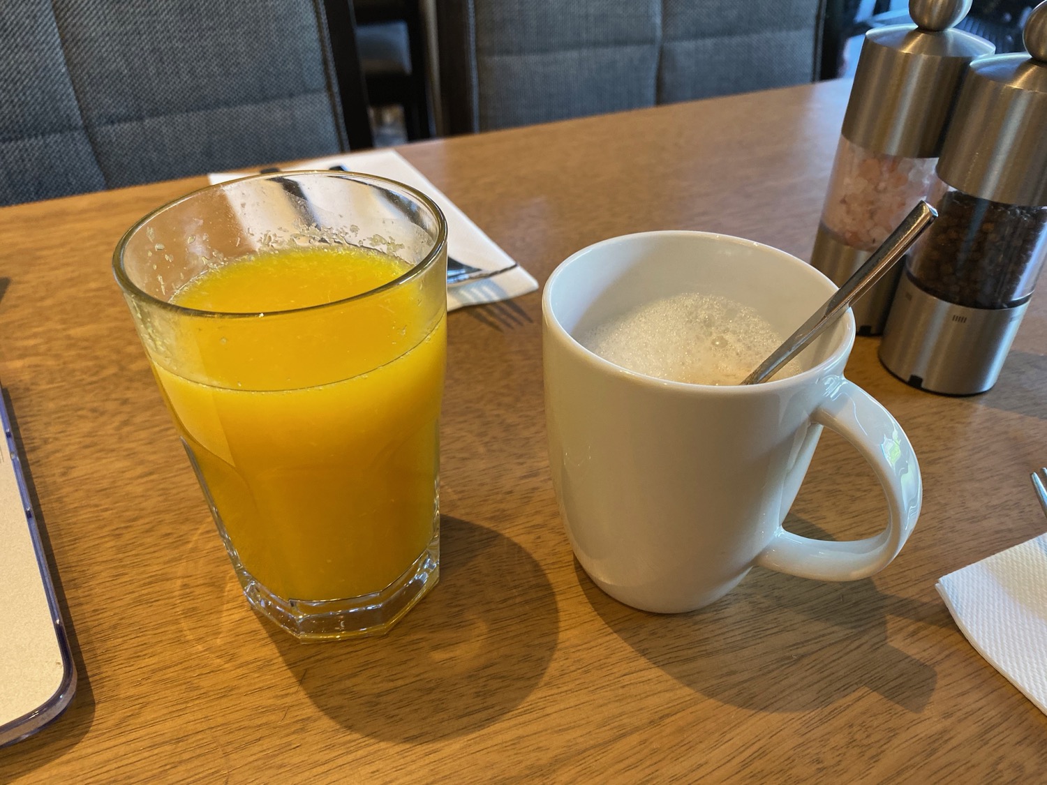 a glass of orange juice next to a mug of coffee