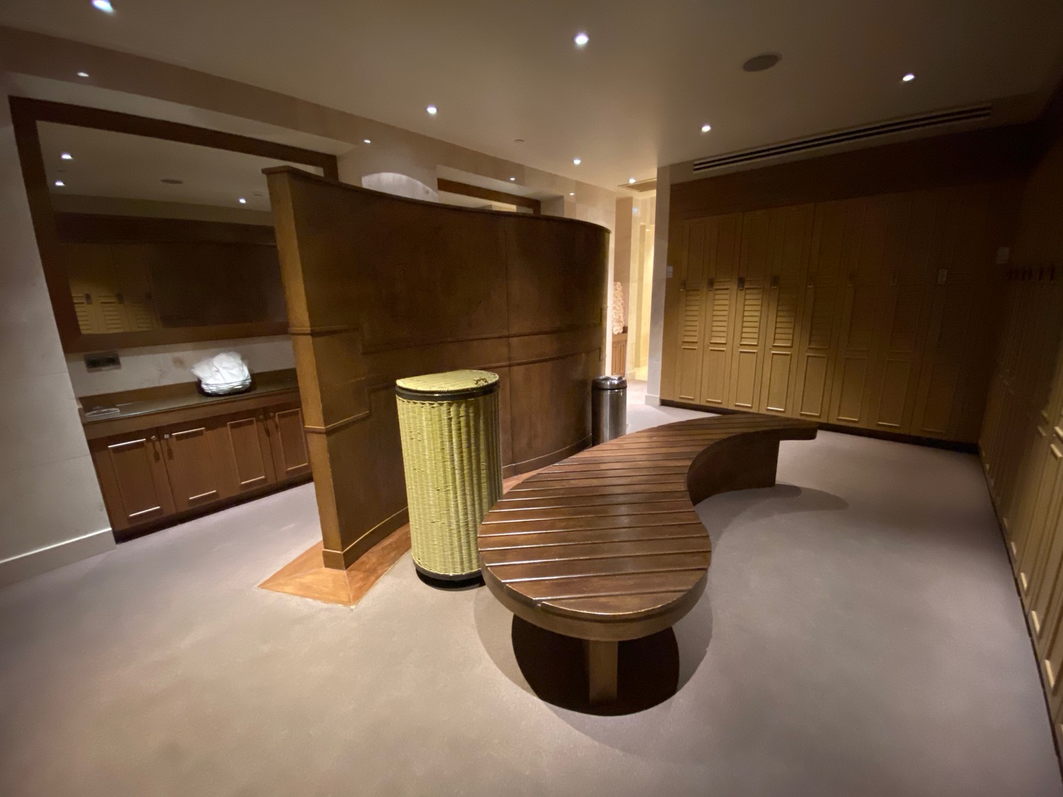 a room with a curved bench and trash can