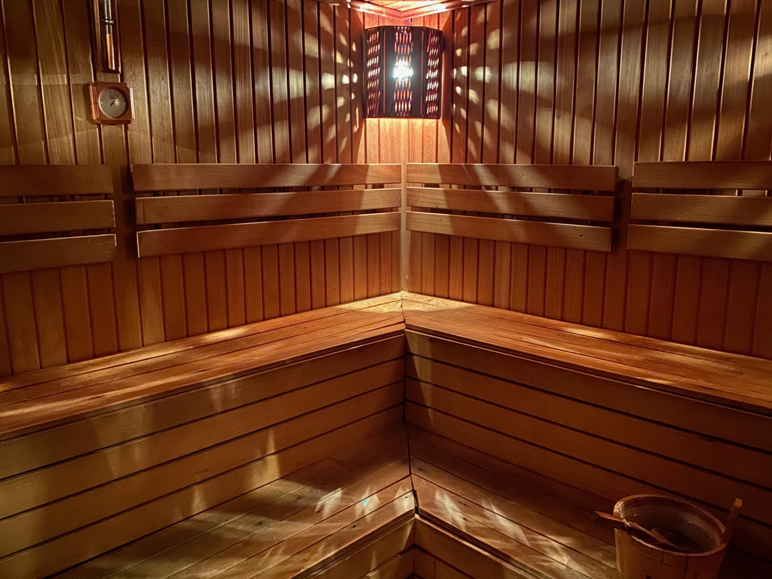 a wooden sauna with a light shining on the wall