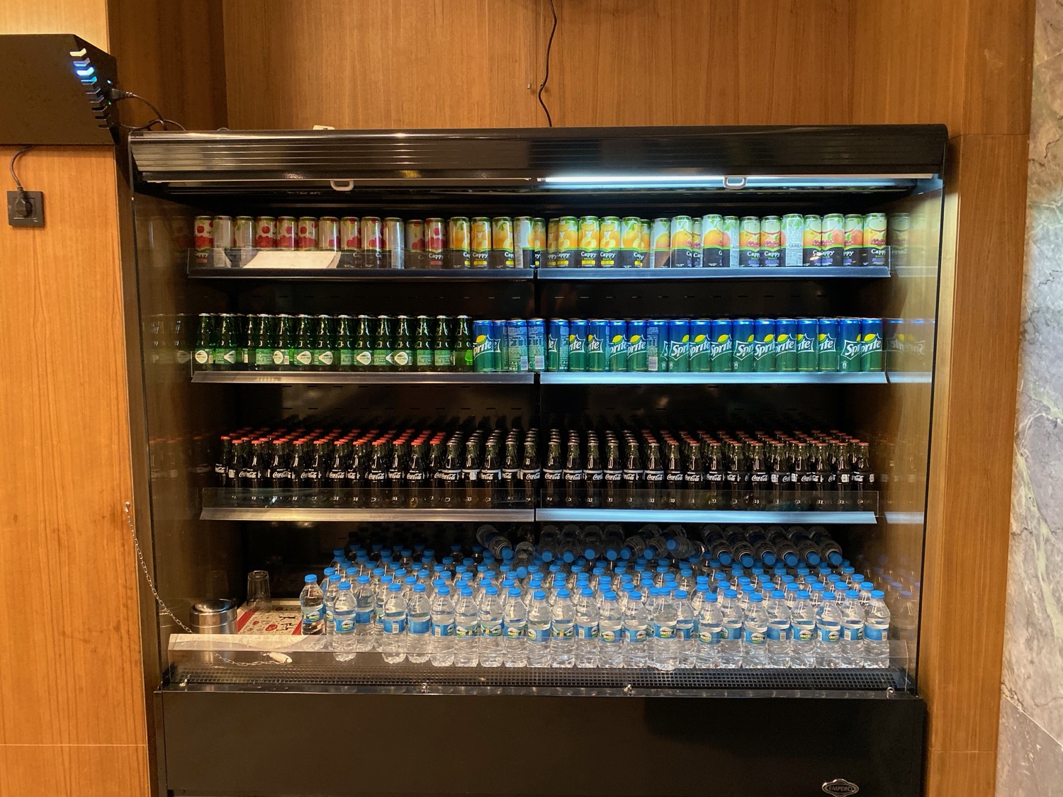 a display case with bottles of soda and water