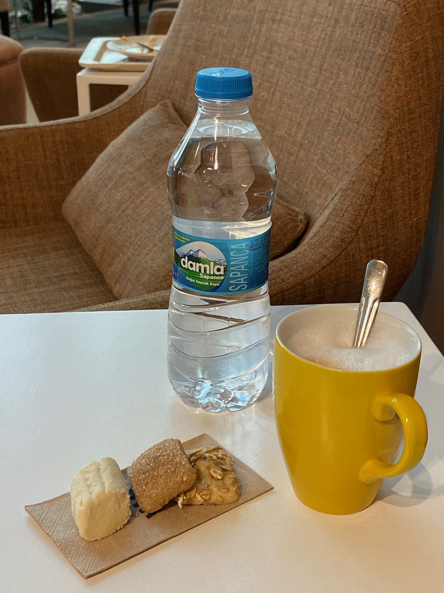 a bottle of water and a yellow mug of coffee