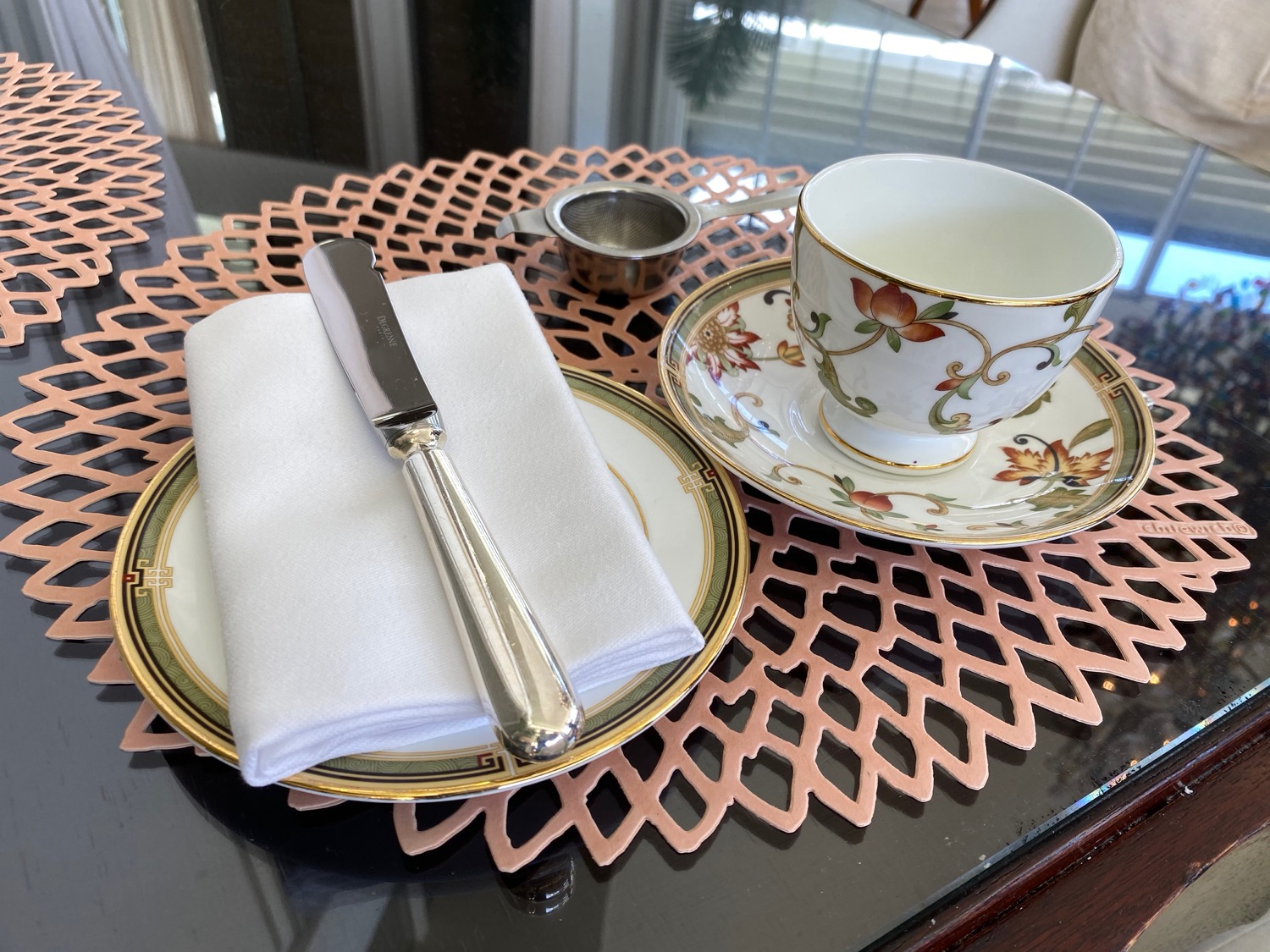 a teacup and saucer with a napkin and a knife on a table