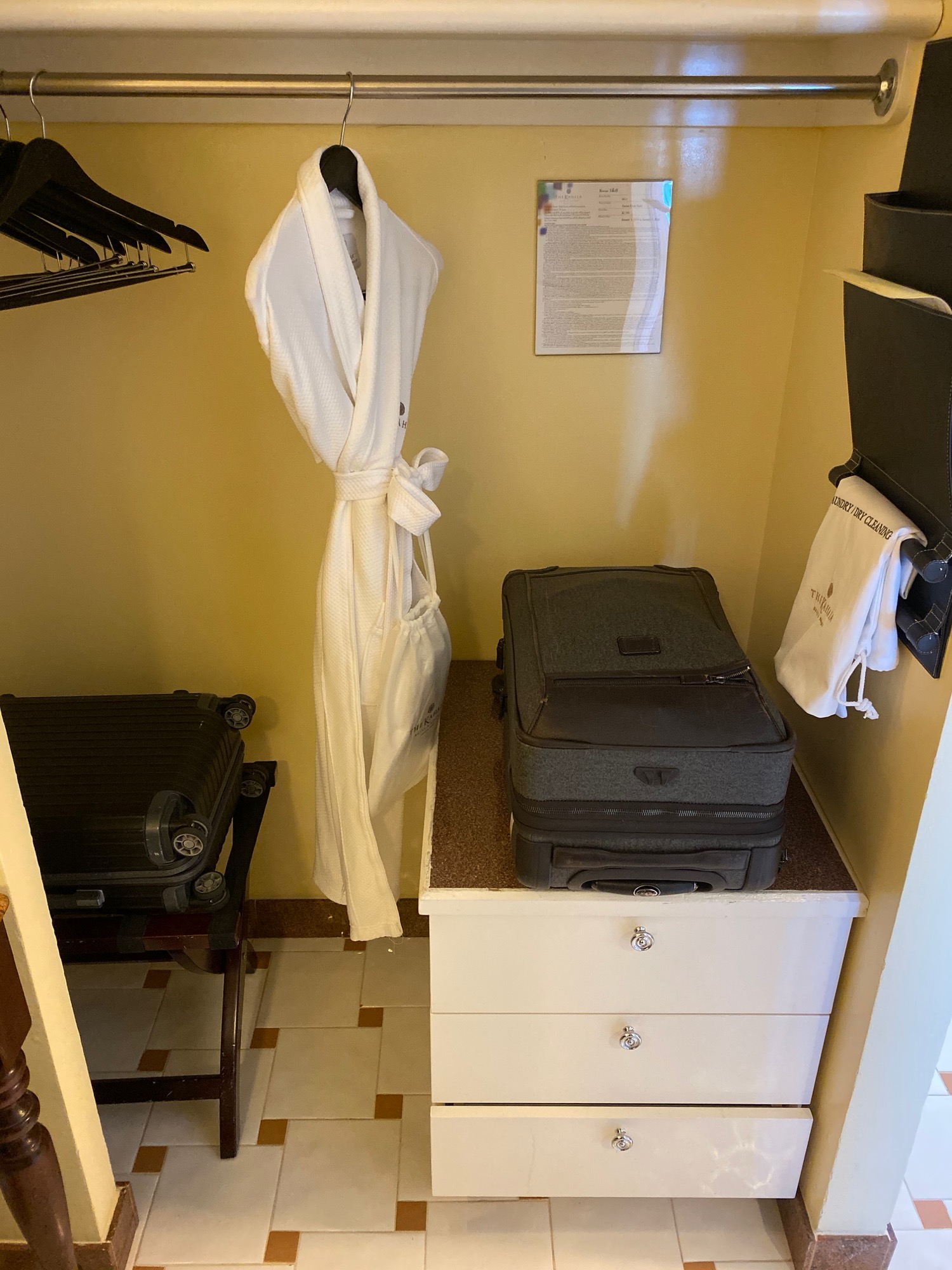 a white robe and luggage in a room