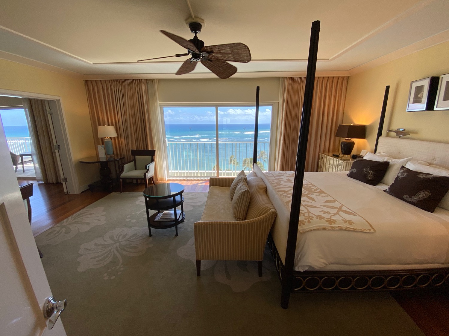 a room with a bed and a window with a view of the ocean