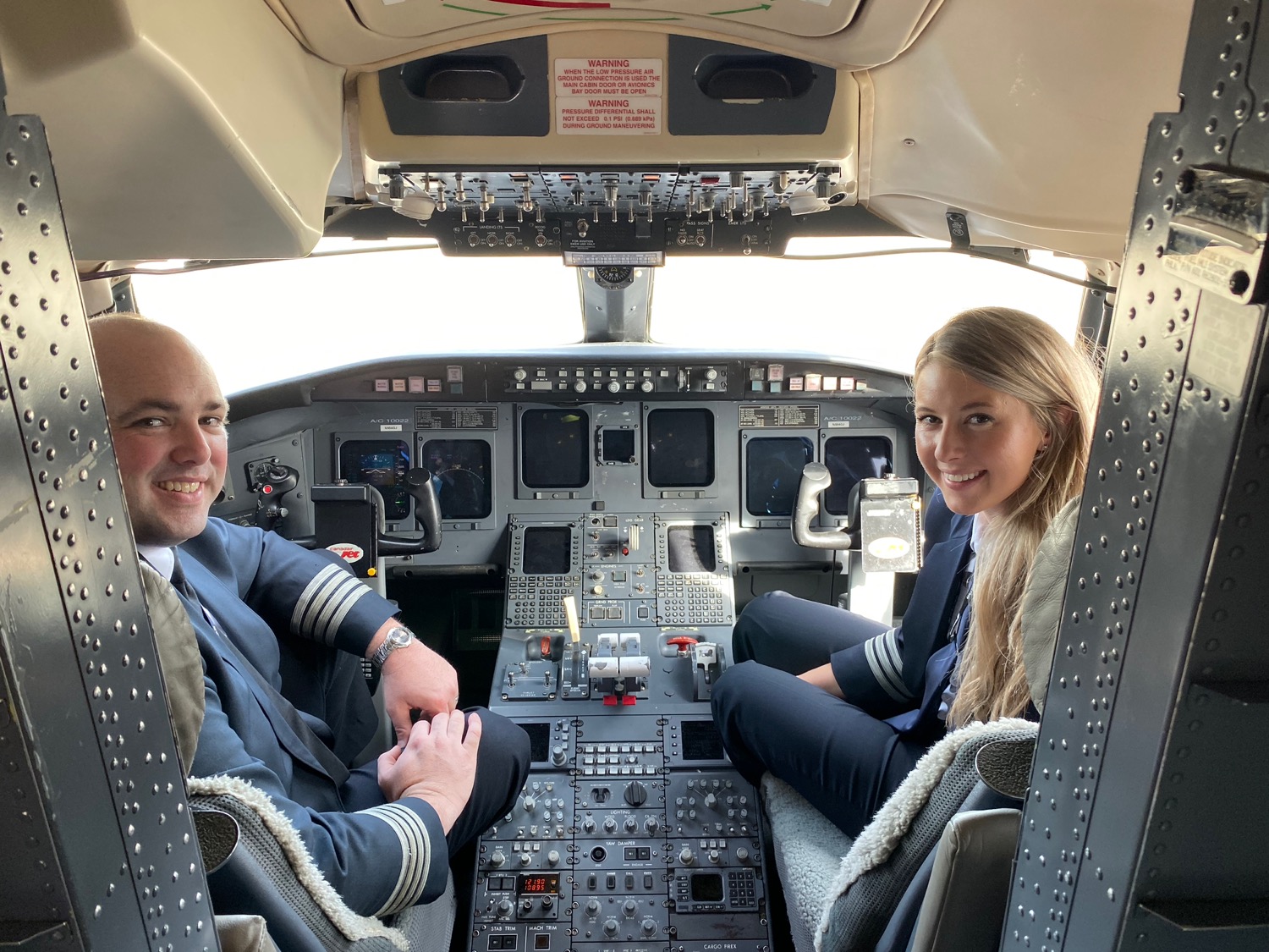 a man and woman sitting in a cockpit of an airplane