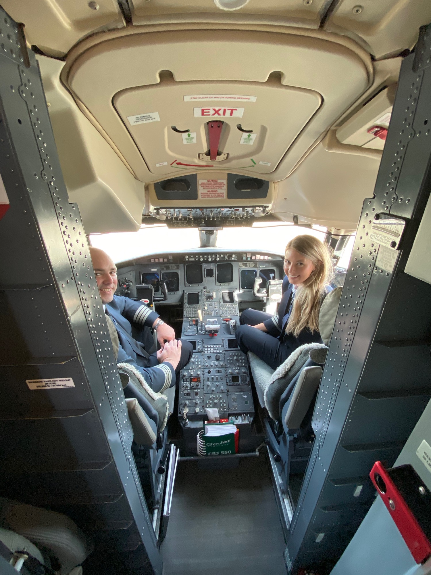 a man and woman sitting in the cockpit of an airplane