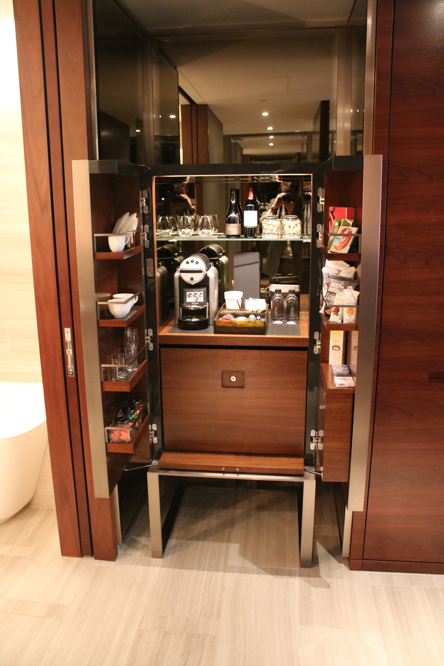 a small cabinet with a coffee machine and a glass door