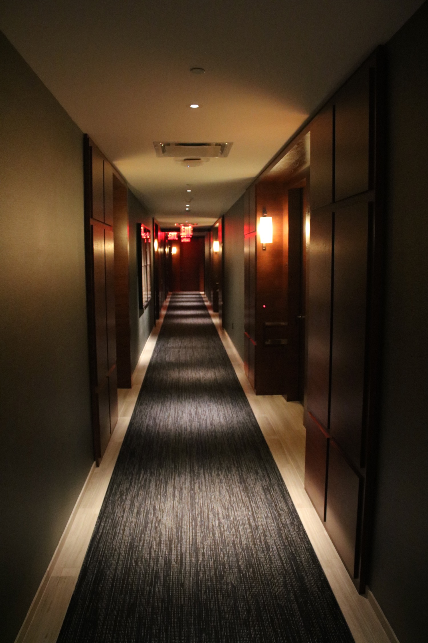 a long hallway with lights and wood cabinets