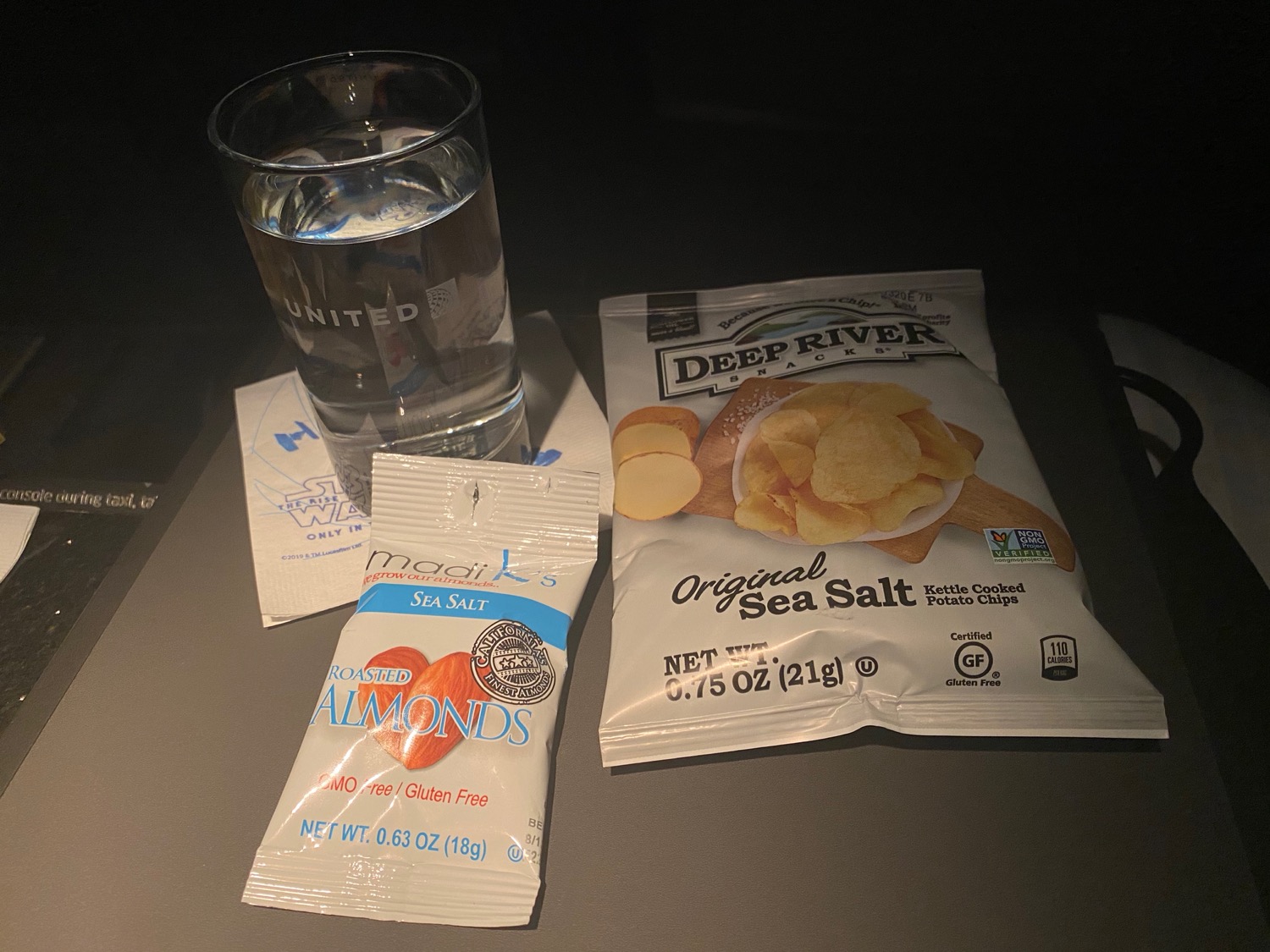 a glass of water and bags of chips