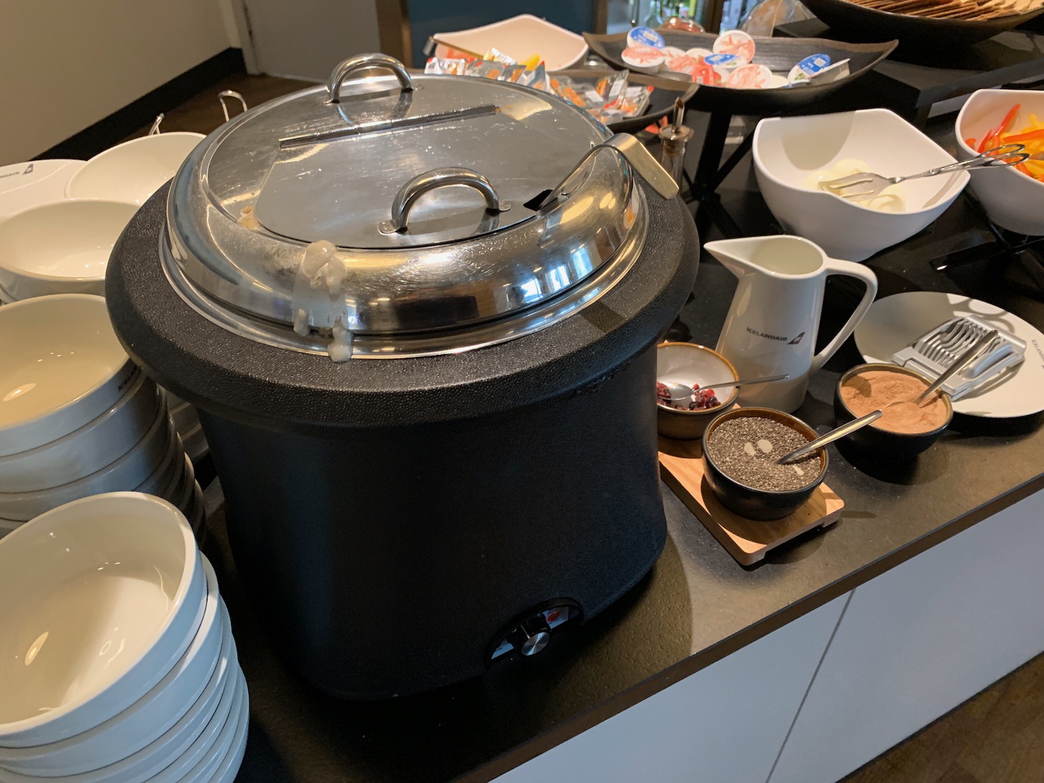 a black pot with a lid on a counter with plates and bowls