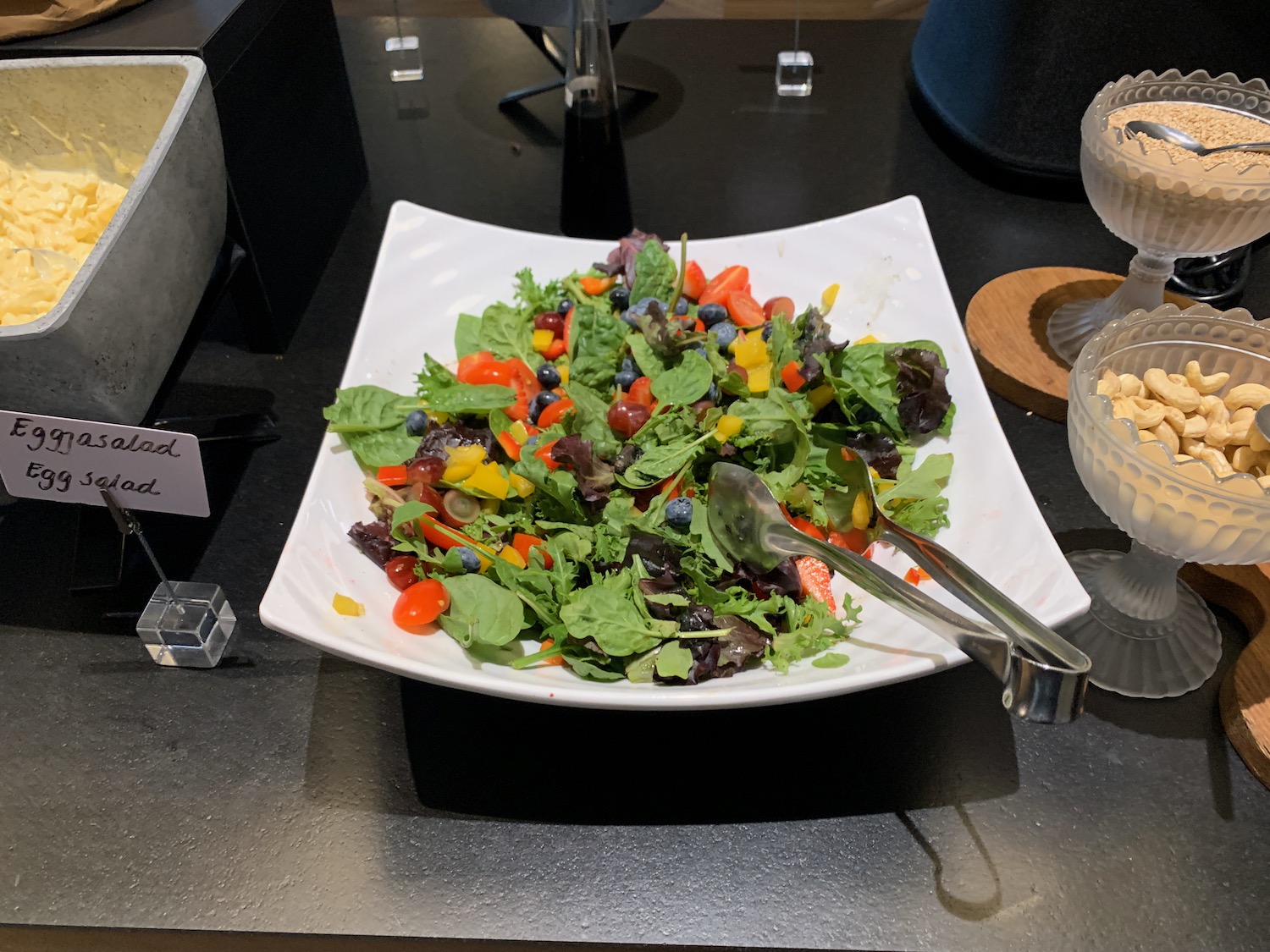 a plate of salad with tongs