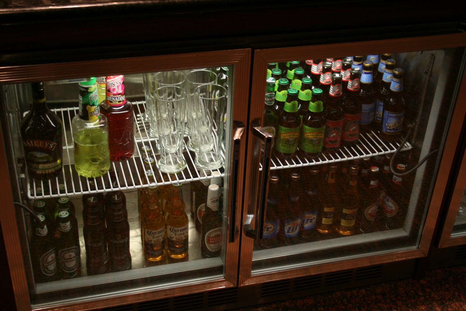 a refrigerator with bottles and glasses