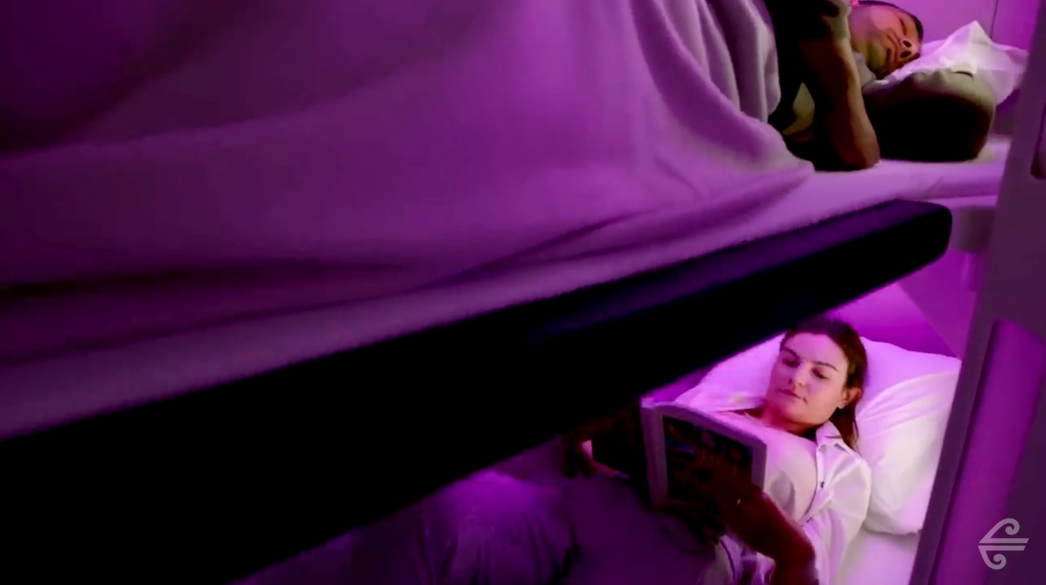 a person lying on a bed reading a book