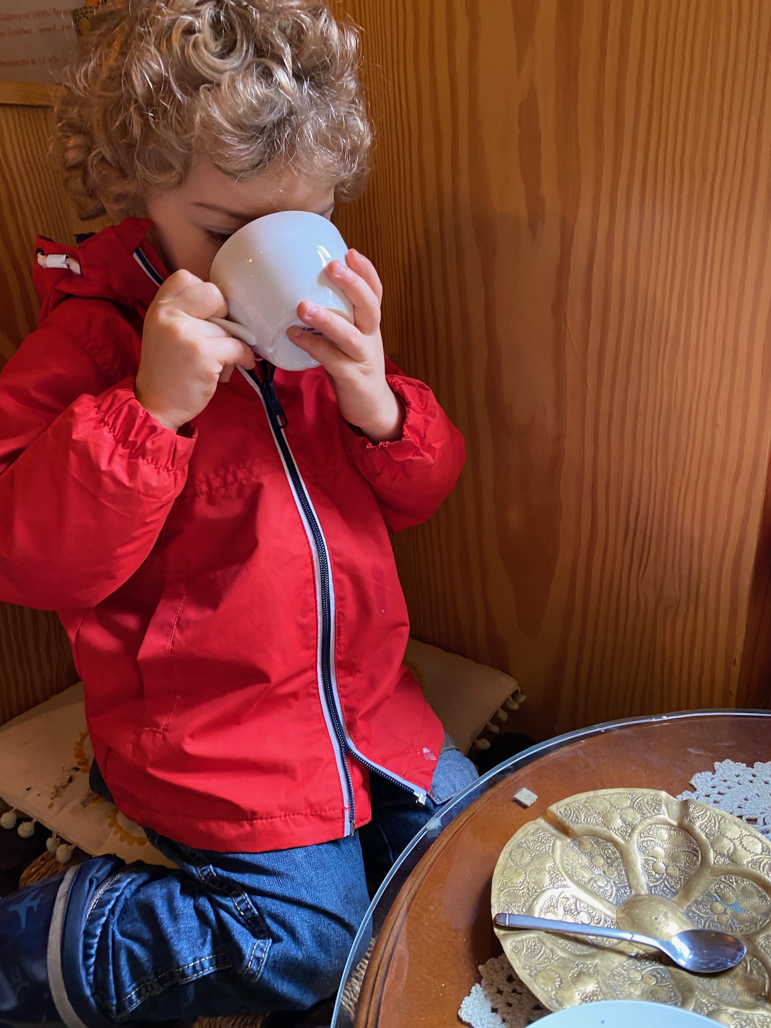 a child drinking from a white mug