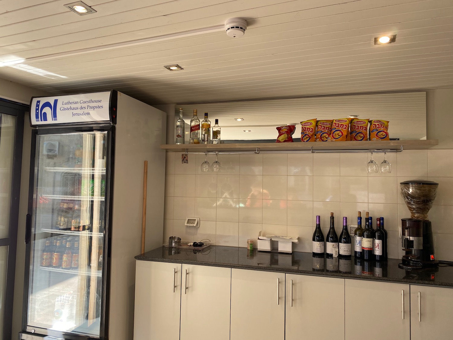 a bar with bottles of wine and snacks on a shelf