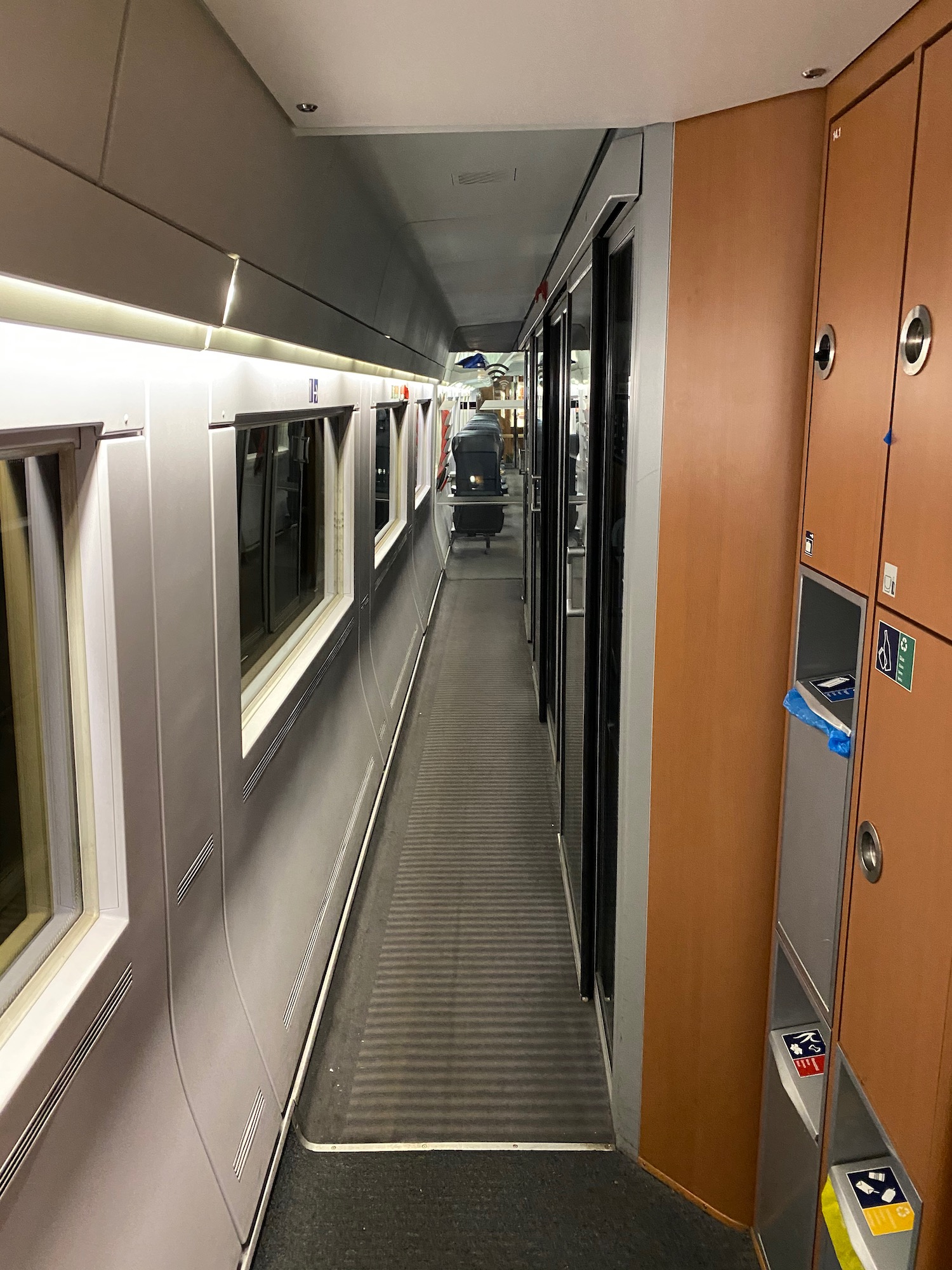 a long hallway with a row of doors and cabinets