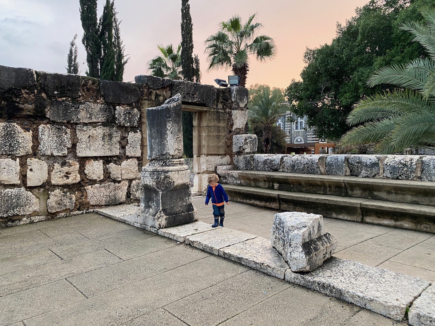 a child standing on a stone wall