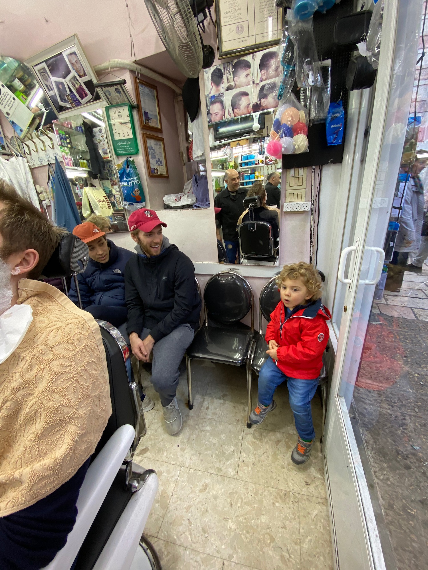a group of people sitting in chairs in a barber shop