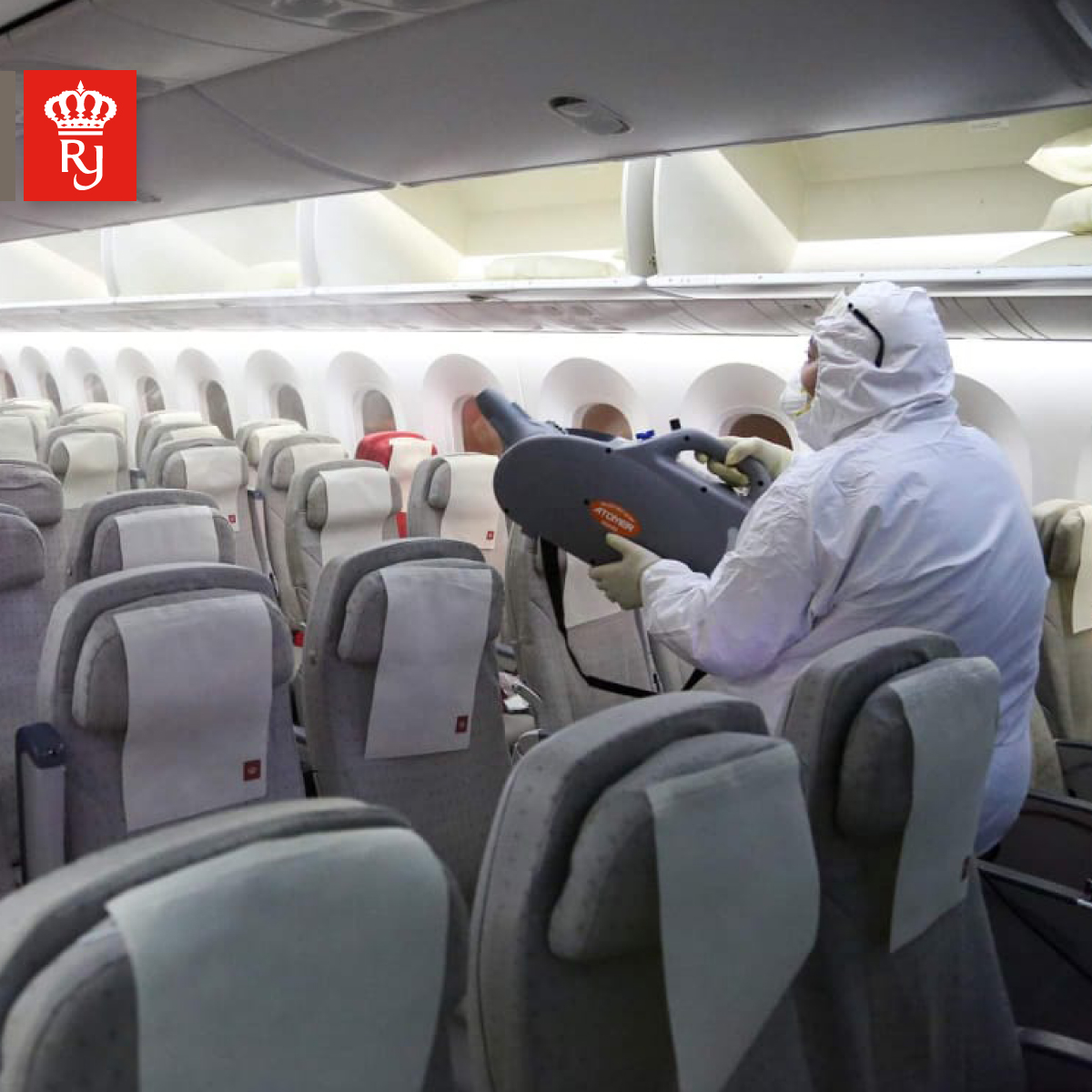 a person in a white suit and protective gear on an airplane