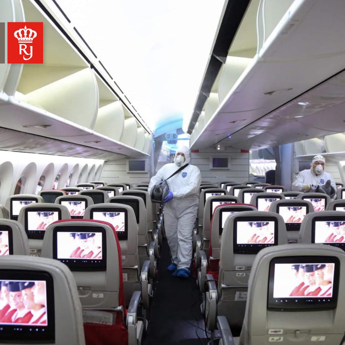 a man in a protective suit and mask standing in an airplane