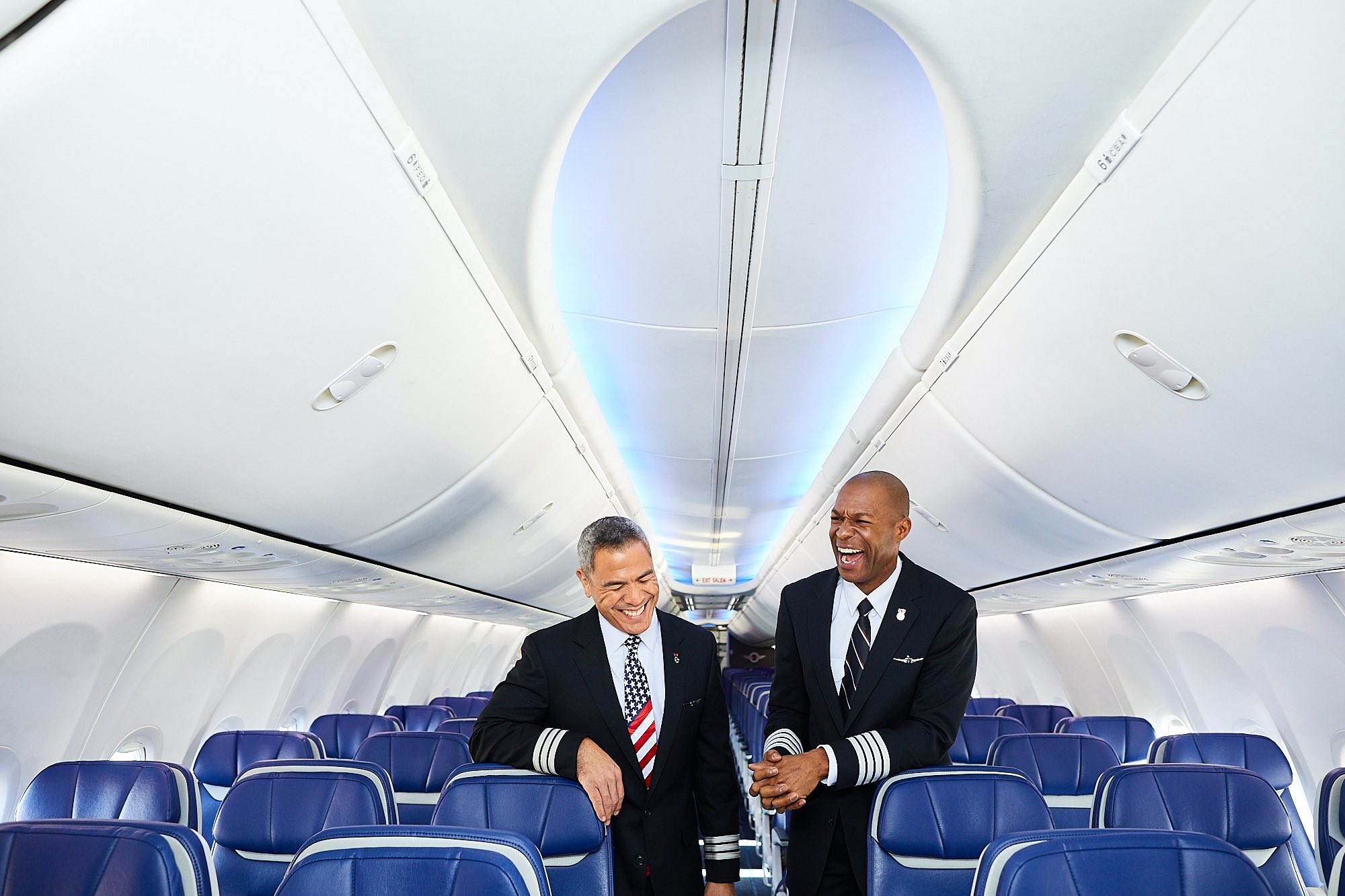 men in black suits standing in an airplane