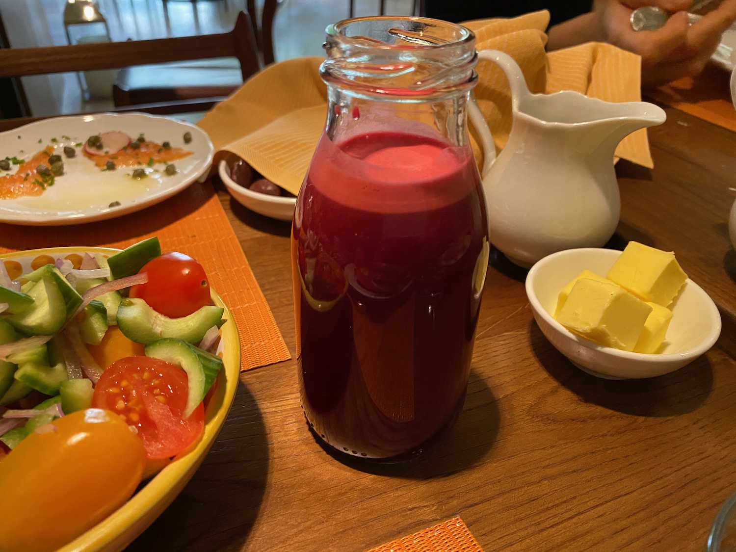 a glass bottle of juice next to a bowl of food