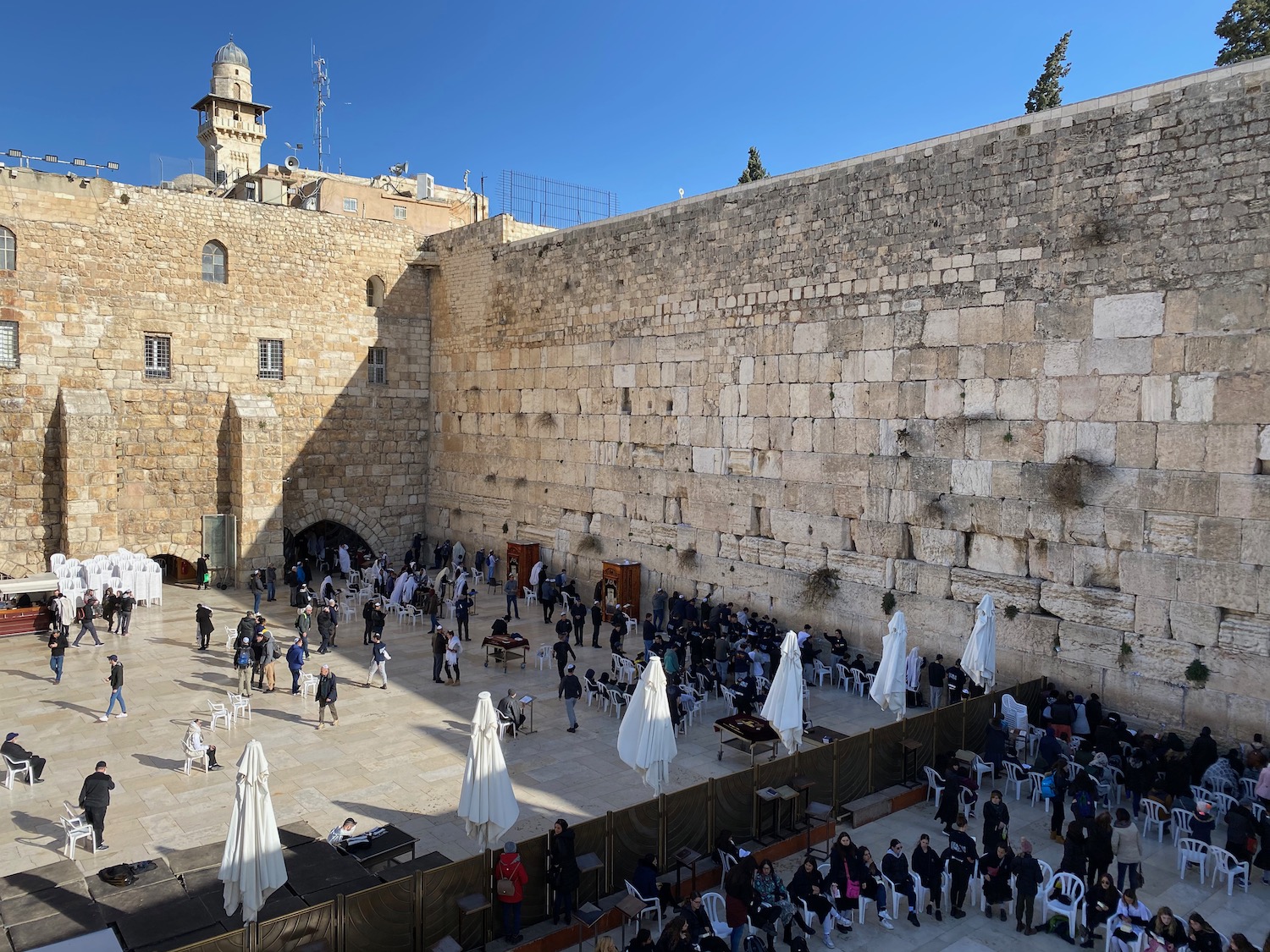 a group of people outside a stone wall with Western Wall in the background