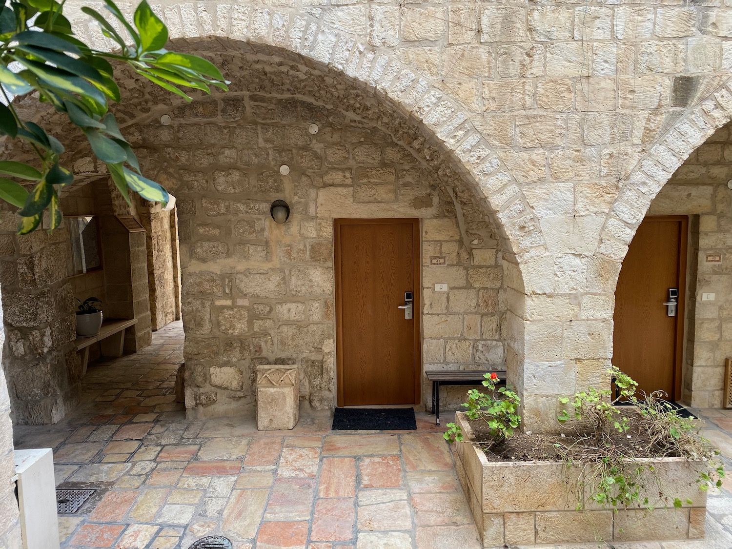 a stone building with a door and plants