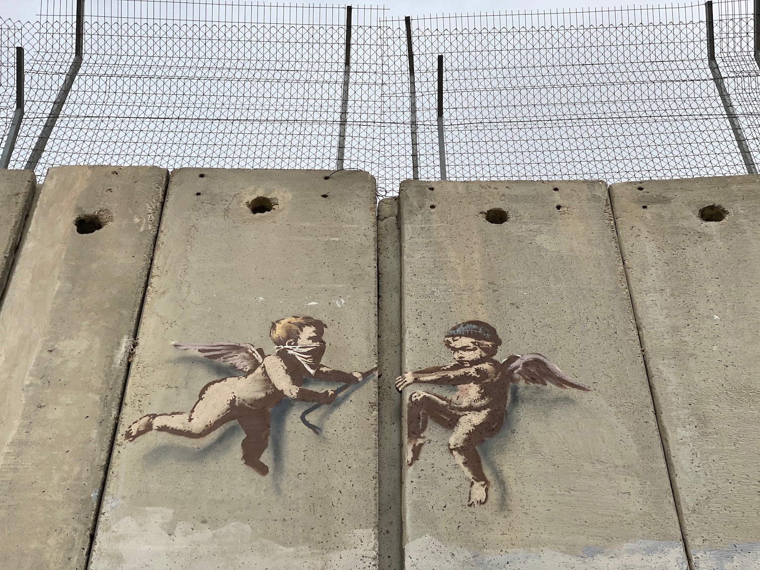 a concrete wall with angels painted on it