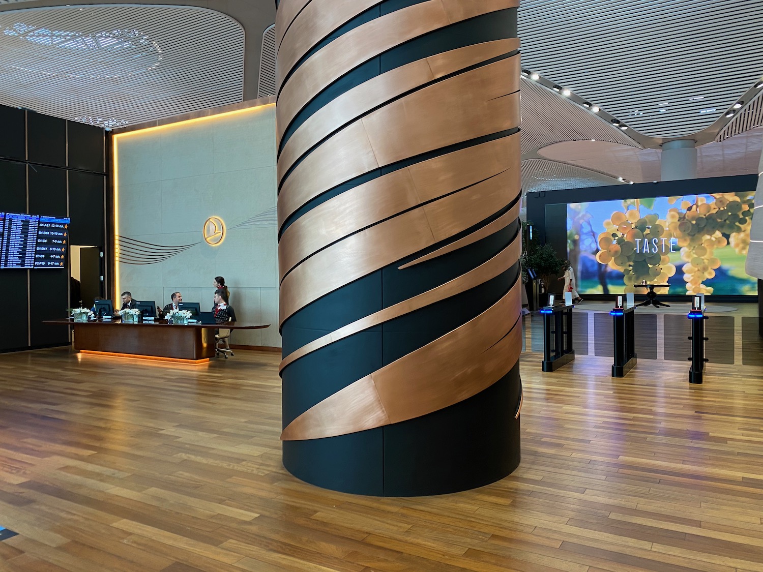 a large black and gold pillar in a room with people sitting at desks