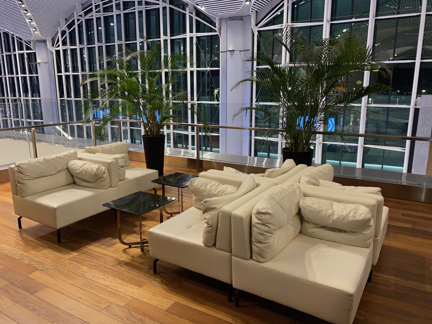 a room with white couches and tables and plants